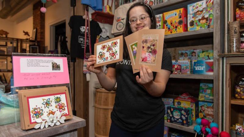 Minal Rosenblum holding up cards she crafted. 