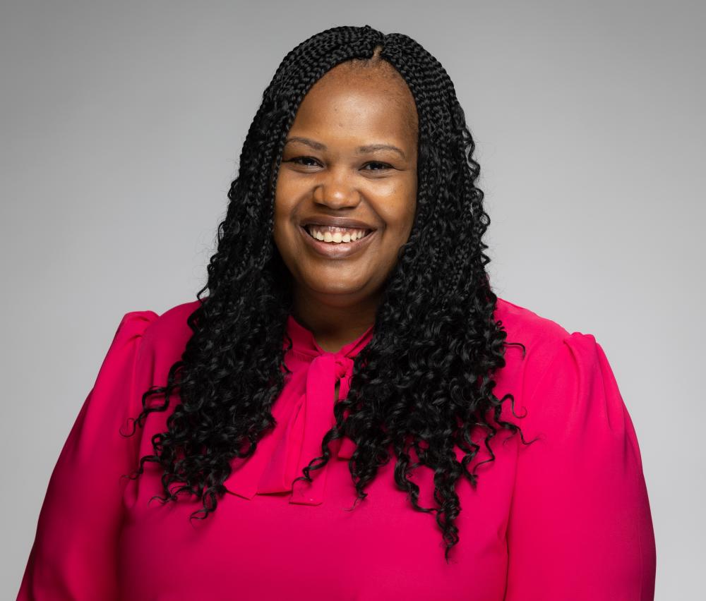 woman smiles in her pink blouse for her headshot