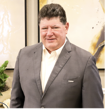 Man smiling in a grey suit for headshot